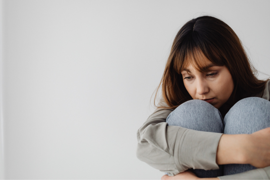 depressed women sitting along a wall