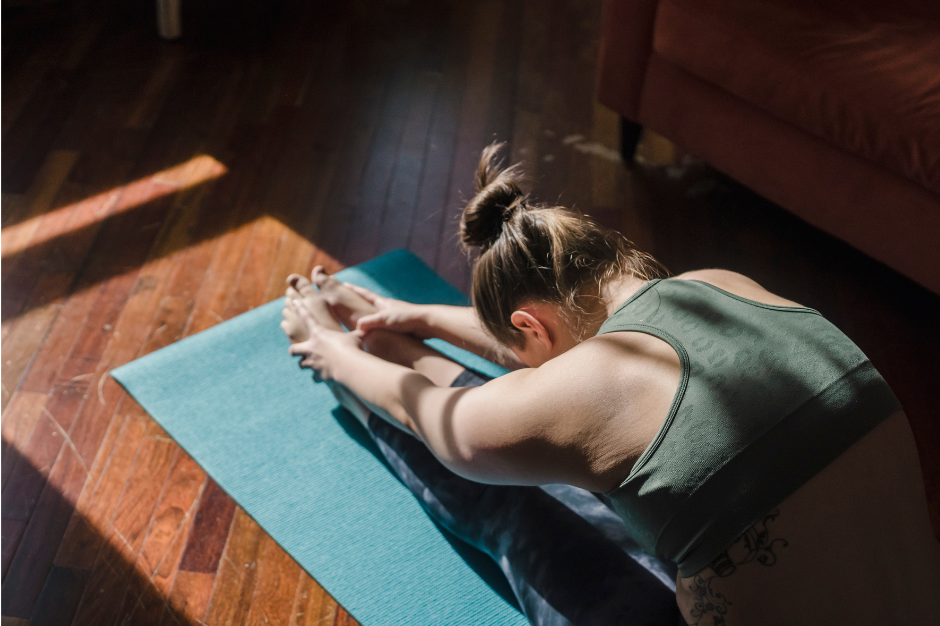 Girl stretching on yoga mat in early sun